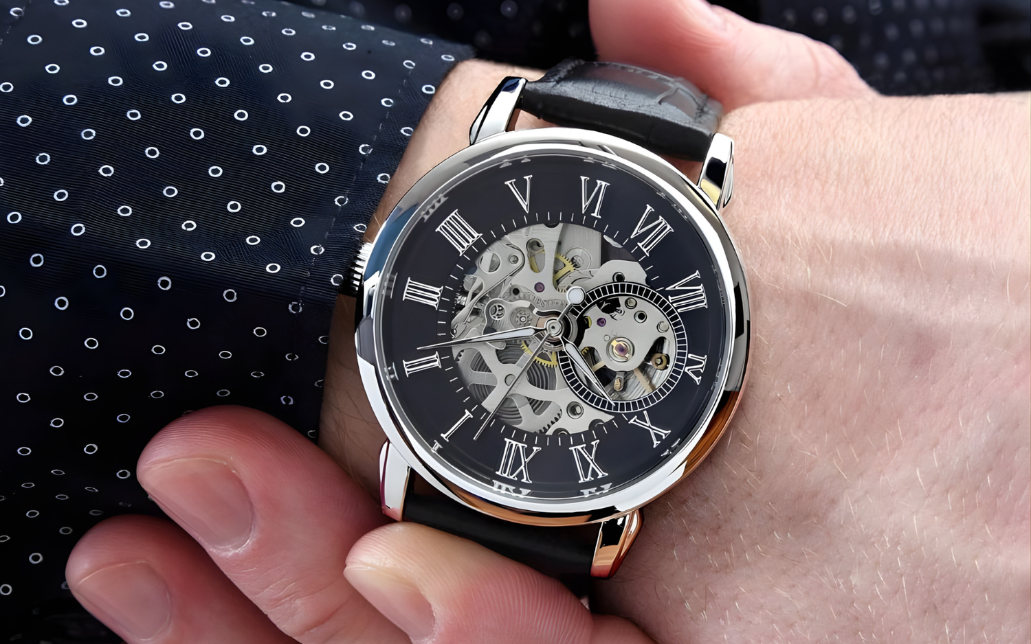 A close-up of the Lumen & Oak Signature Openwork watch on a man's wrist, featuring a black Roman numeral dial and an intricate skeletal mechanical movement visible through the openwork face.