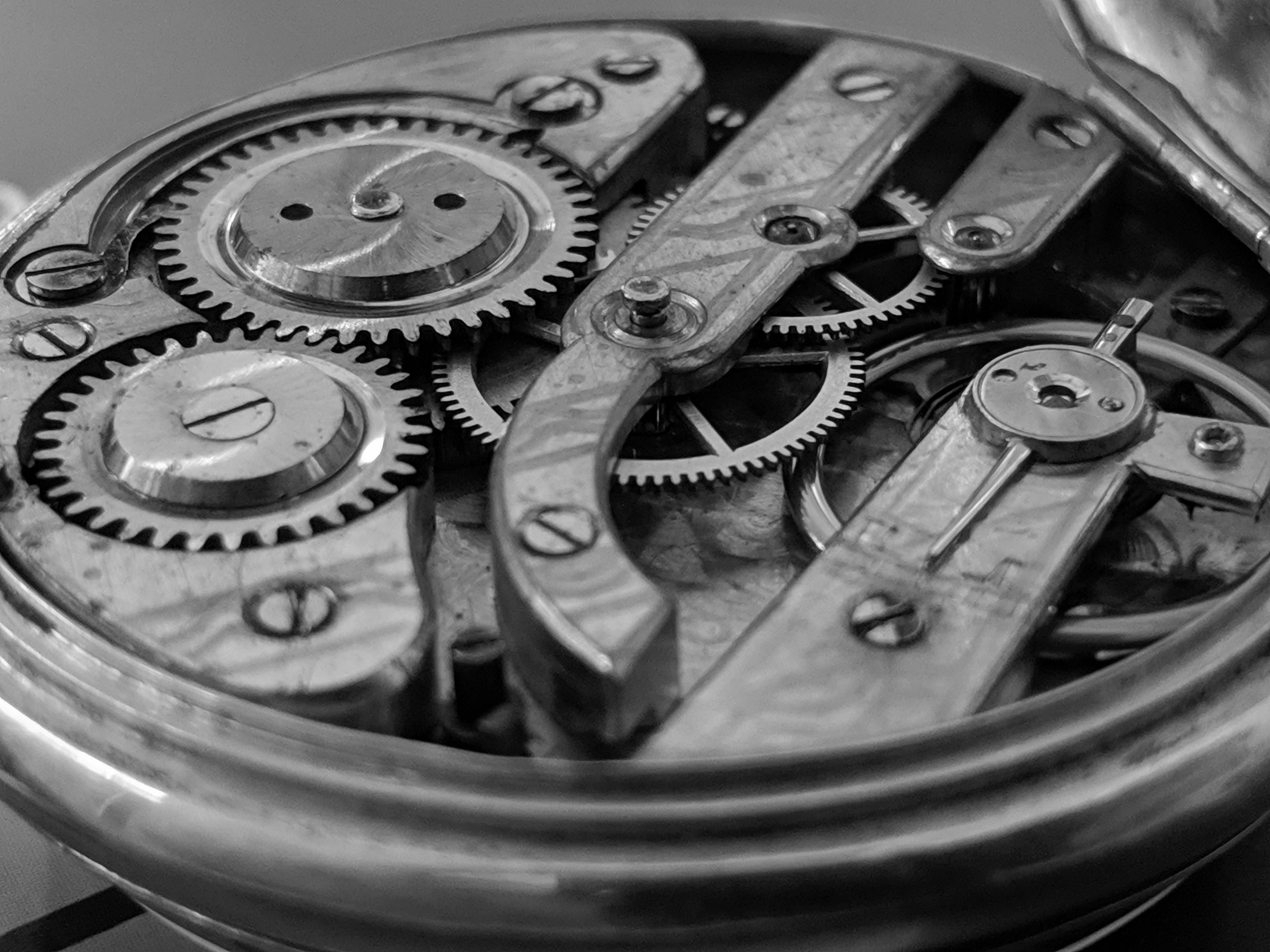 Extreme macro view of the hand-finished gears, escapement, and mechanical components of a Lumen & Oak skeletal watch movement.